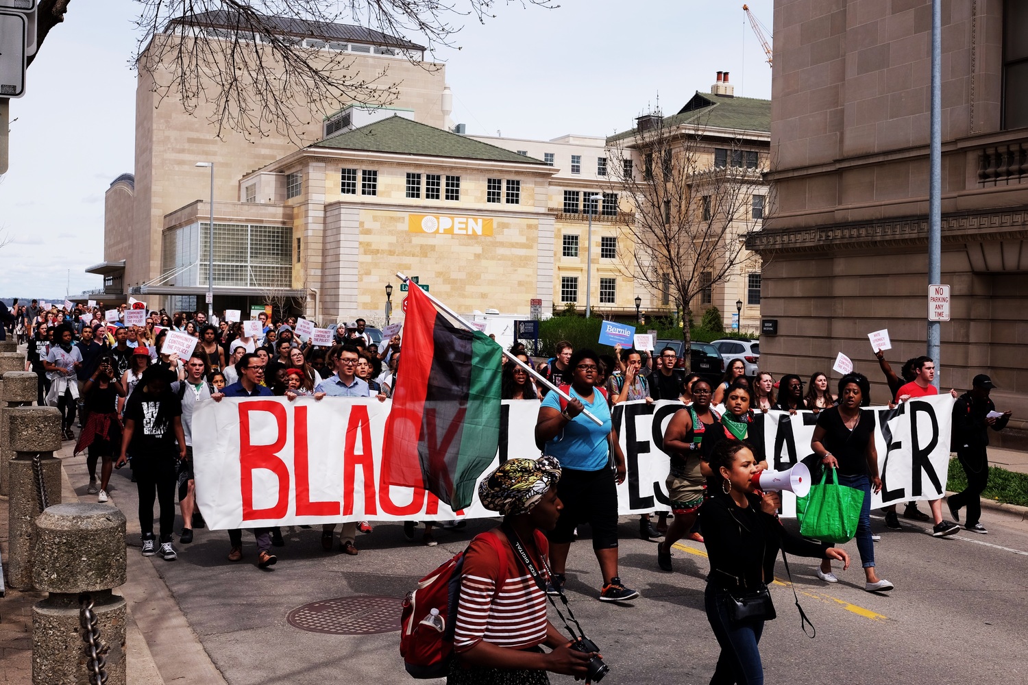 Marching down Park Street between Science Hall and the Wisconsin State Historical Society, with Memorial Union and Union Theatre in the background.